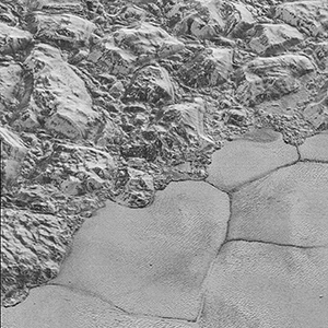 Mountains of ice along a portion of smoother ice planes on Pluto’s surface.